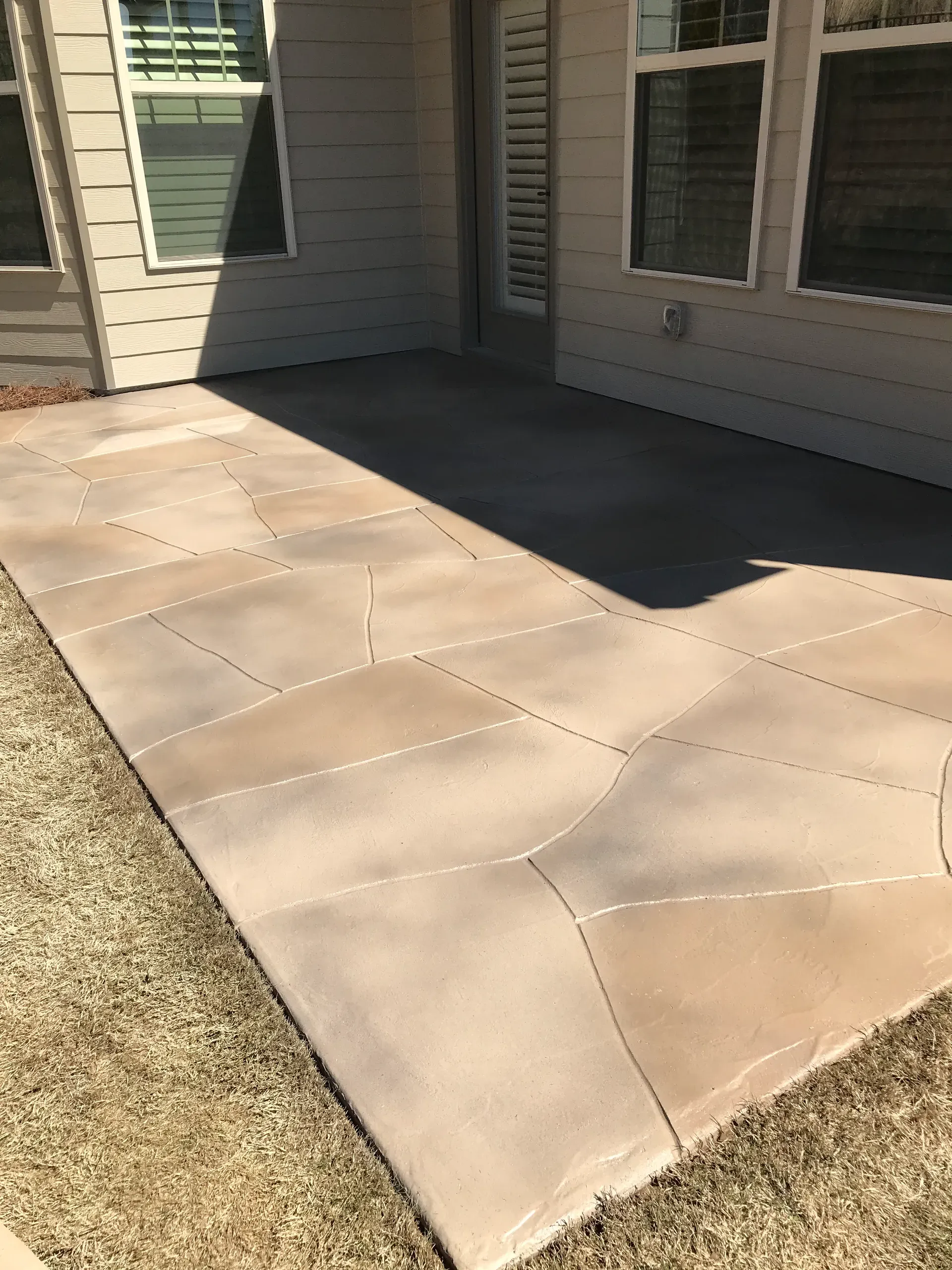 Flagstone-pattern stained concrete patio overlay behind a Kennesaw, Georgia home