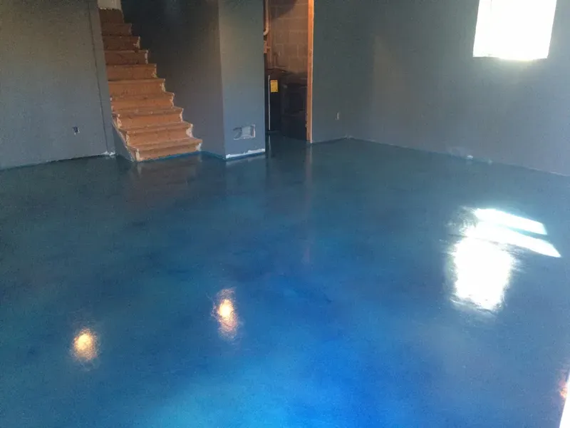 Vibrant blue acid-stained basement concrete floor by JP Concrete Creations
