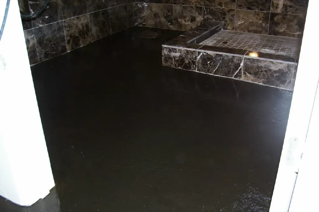 Dark espresso stained concrete bathroom floor paired with marble tile