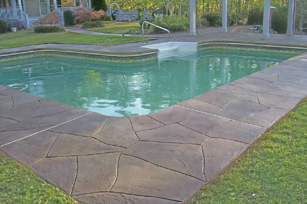 Pool deck with a random flagstone pattern overlay in warm brown tones at a metro Atlanta home