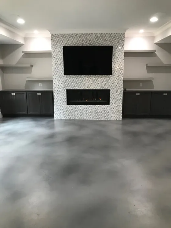 Gray stained interior concrete floor with a tiled fireplace feature wall and built-ins